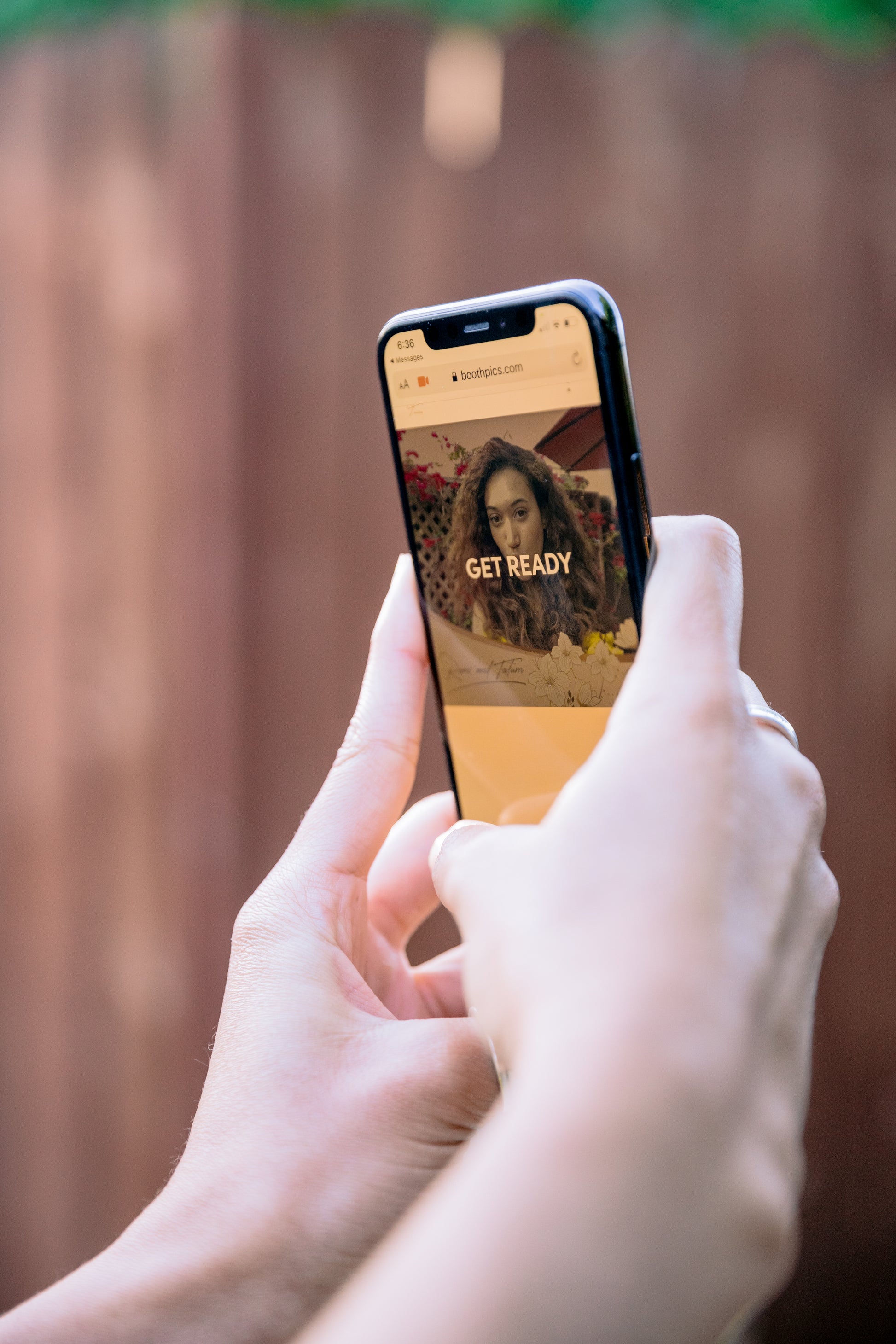 Person holding a smartphone displaying a virtual booth invitation, perfect for capturing memories.